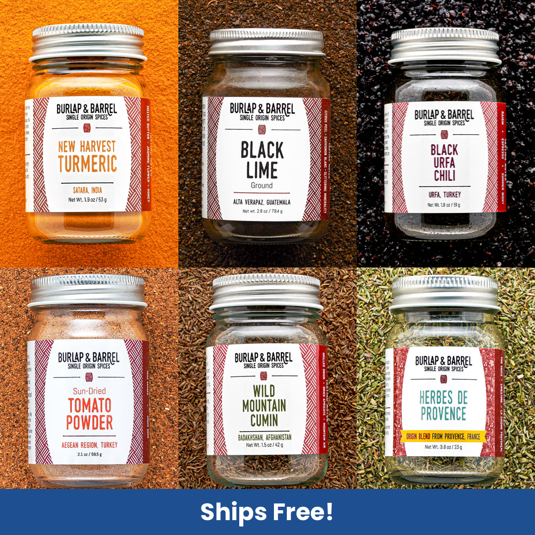 Collection of Burlap & Barrel spice jars with labels on a textured background