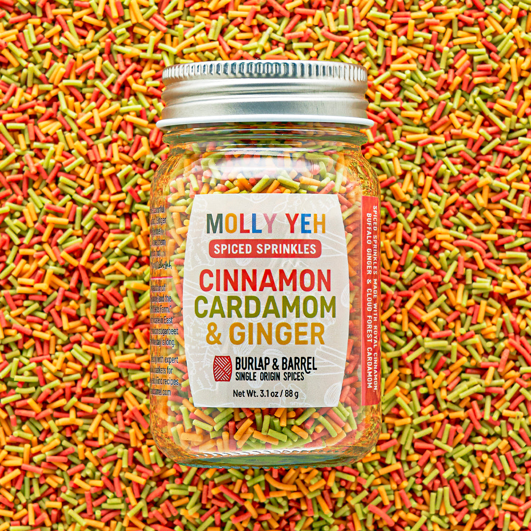 Jar of Molly Yeh & Burlap & Barrel Spiced Sprinkles with colorful sprinkles in the background