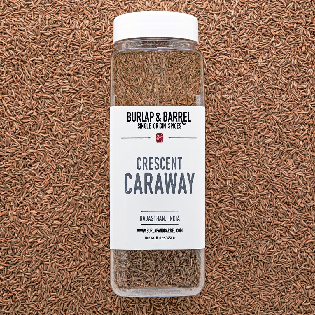 Bottle of Burlap & Barrel Crescent Caraway on a caraway seed background from Burlap & Barrel