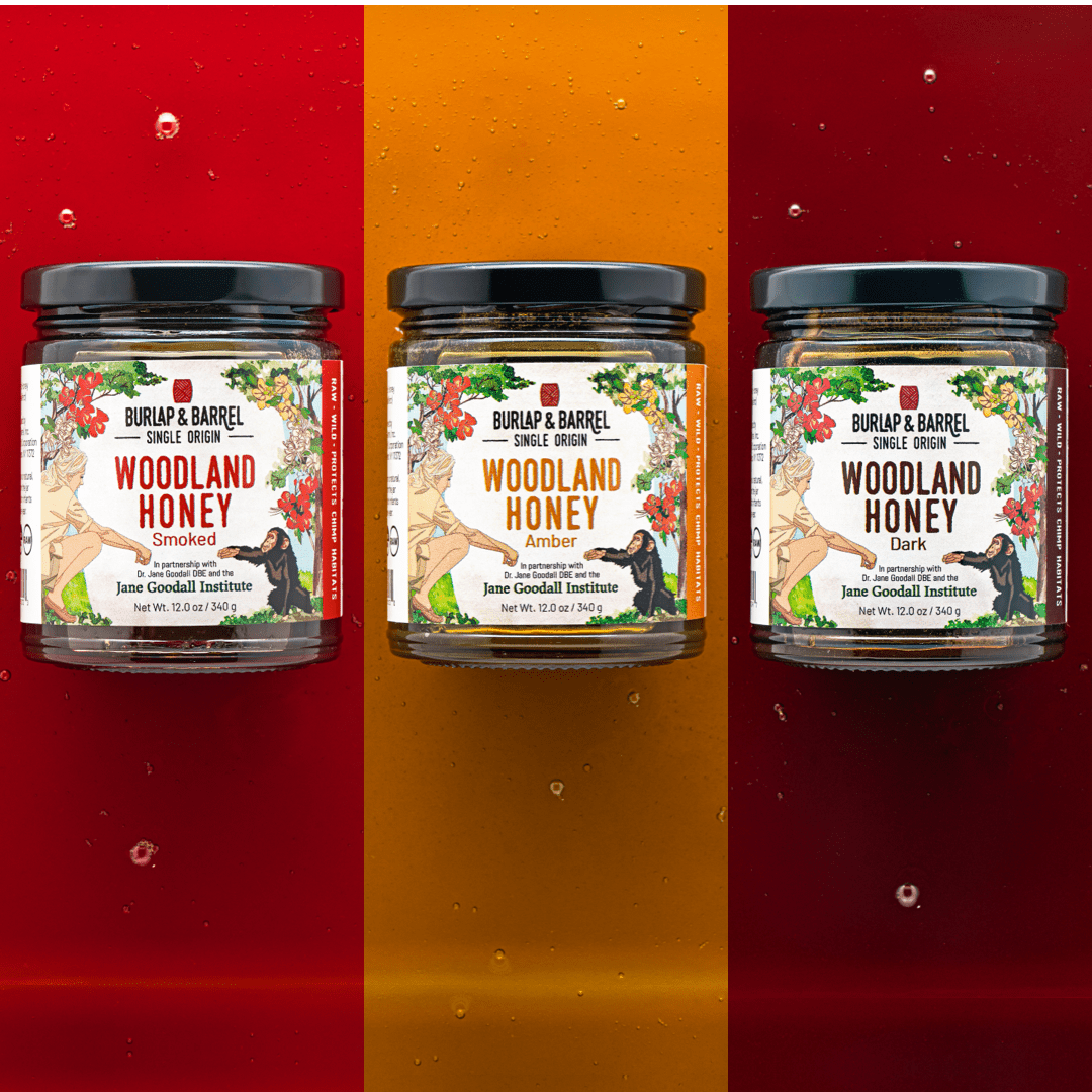 Three jars of Burlap & Barrel Woodland Honey on orange, yellow and red background.