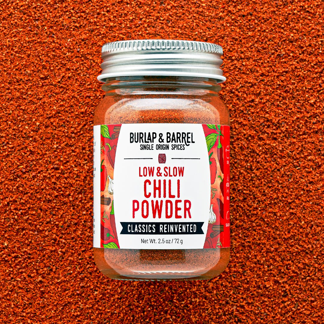 Jar of Burlap & Barrel Low & Slow Chili Powder on a textured brown background