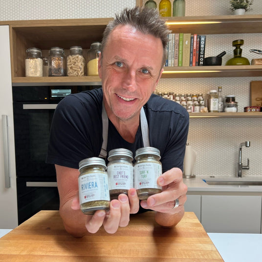 Chef Marc Murphy holding three jars of his spice blends