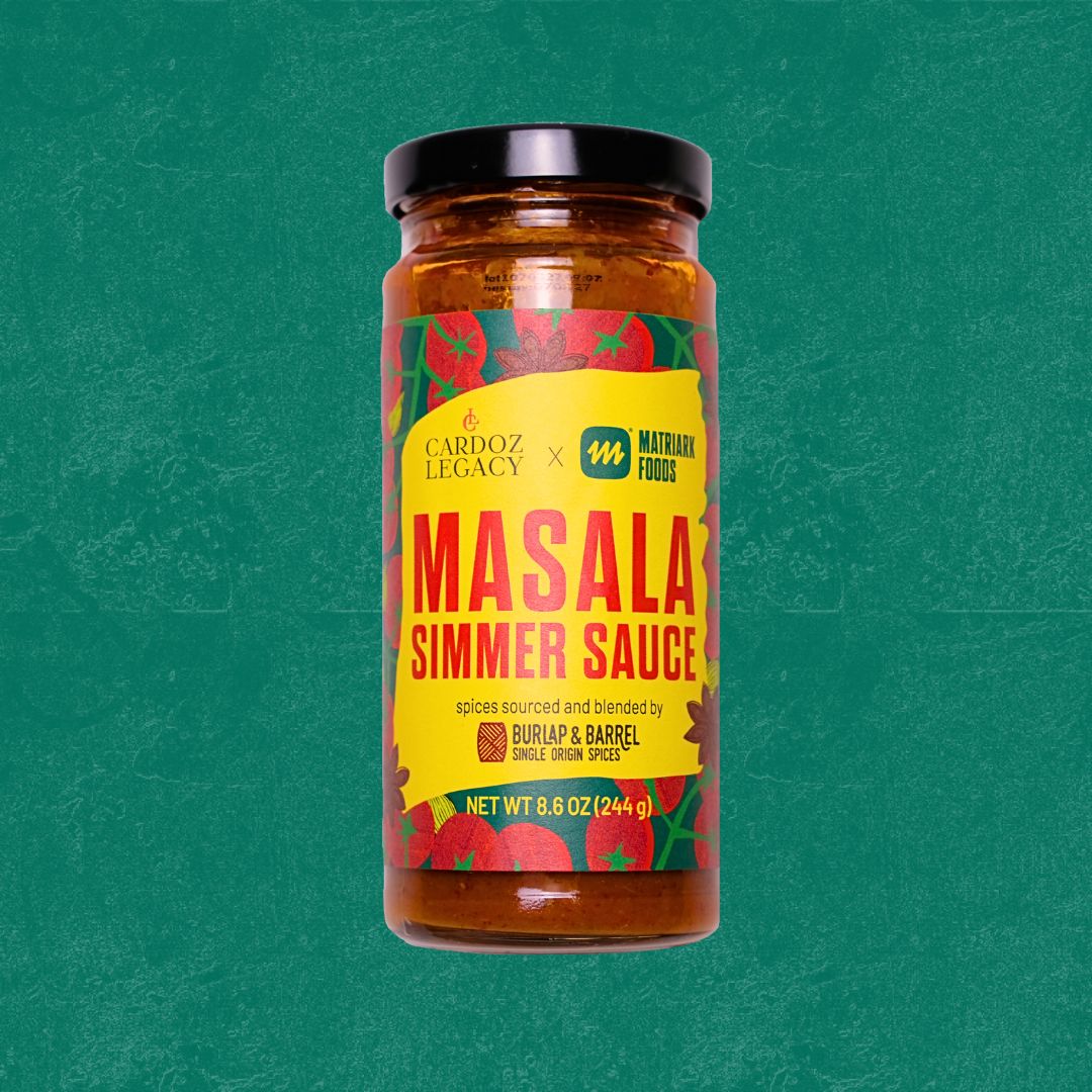 Jar of Masala Simmer Sauce with a green background by Burlap & Barre;
