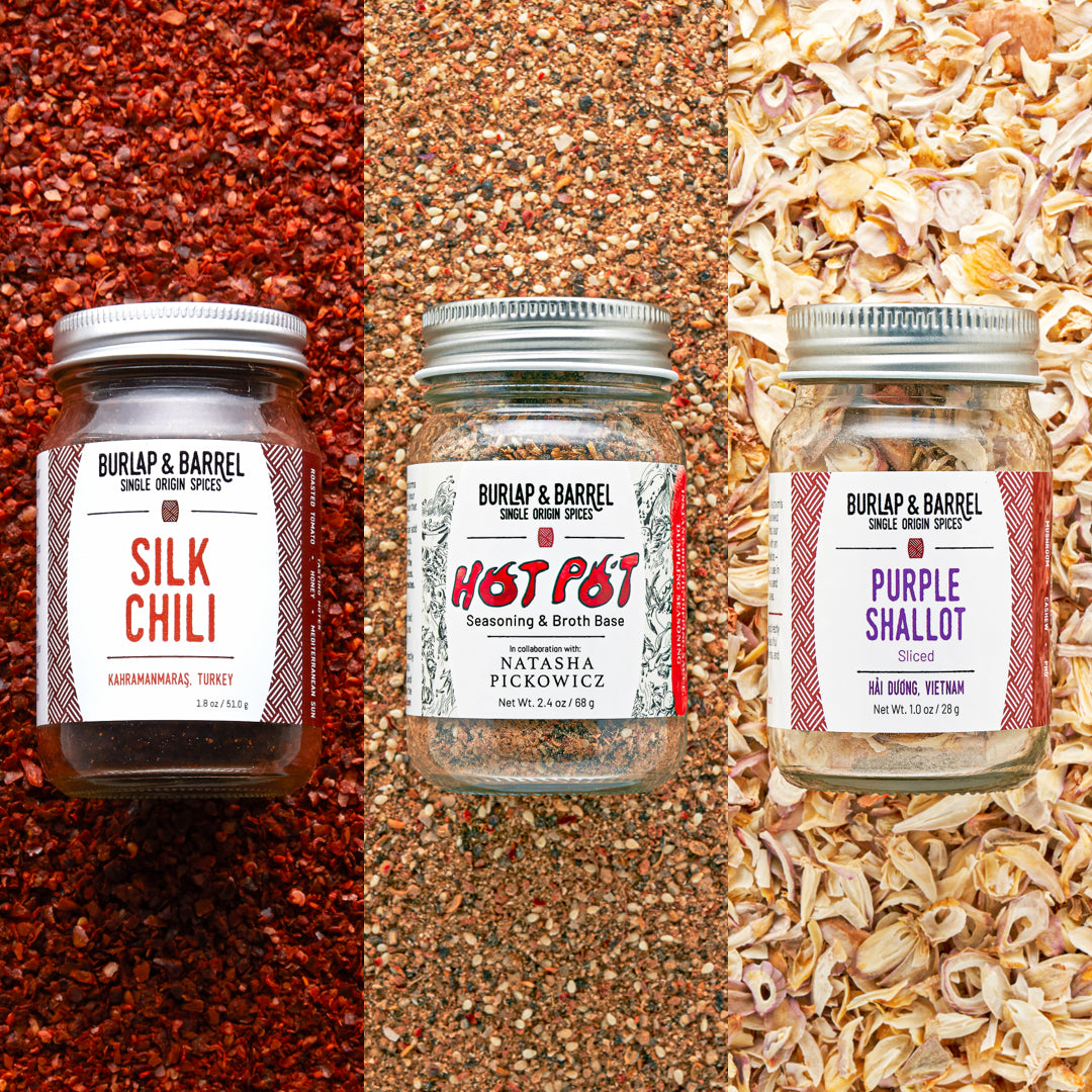 Three jars of Burlap & Barrel spices on a textured background