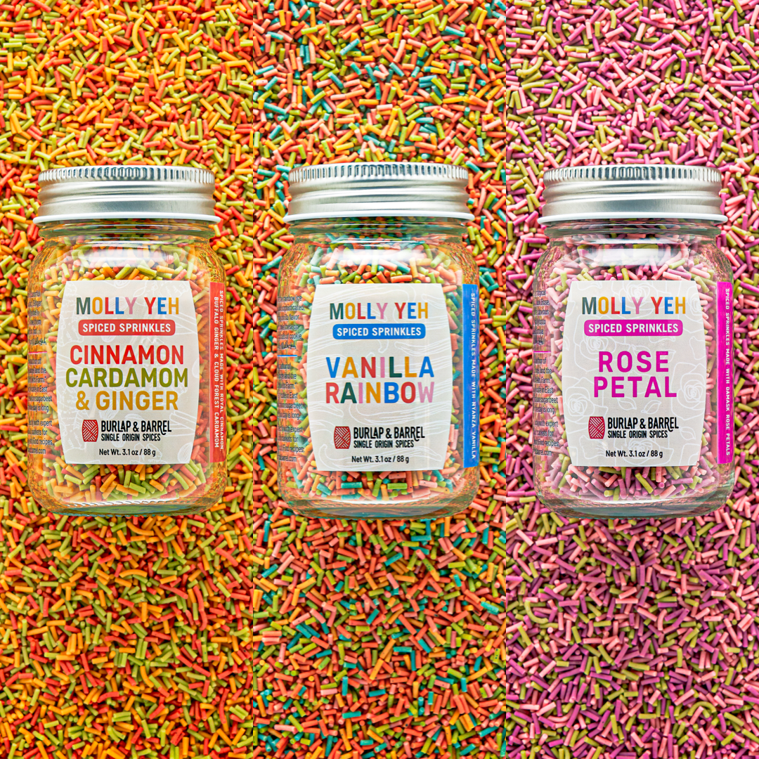 Three jars of Molly Yeh sprinkles on a colorful sprinkle background
