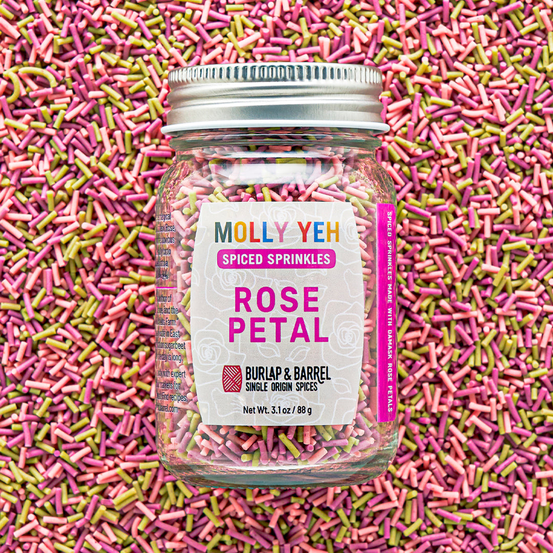 Jar of Molly Yeh & Burlap & Barrel Spiced Sprinkles with colorful sprinkles in the background
