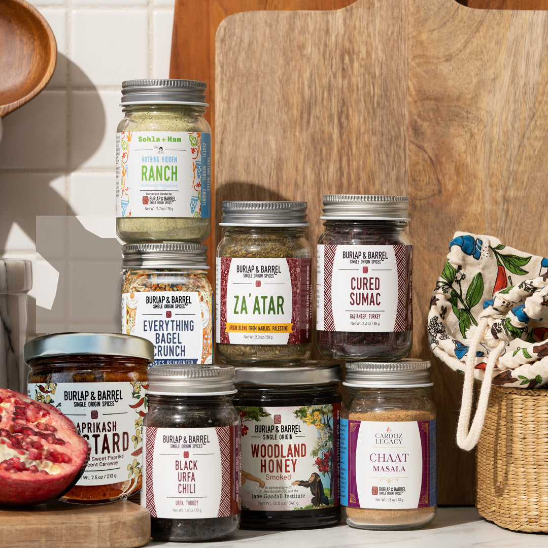 Big Bite Snack Attack bundle with six spice jars, Smoked Woodland Honey and Paprikash Mustard, beside a printed cotton gift bag.