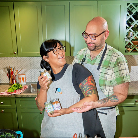 Sohla & Ham El-Waylly with their Burlap & Barrel collaboration spice blends in a green kitchen.