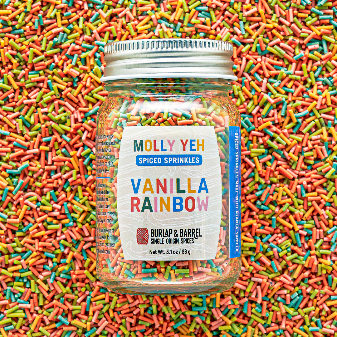 Jar of Molly Yeh & Burlap & Barrel Spiced Sprinkles with colorful sprinkles in the background