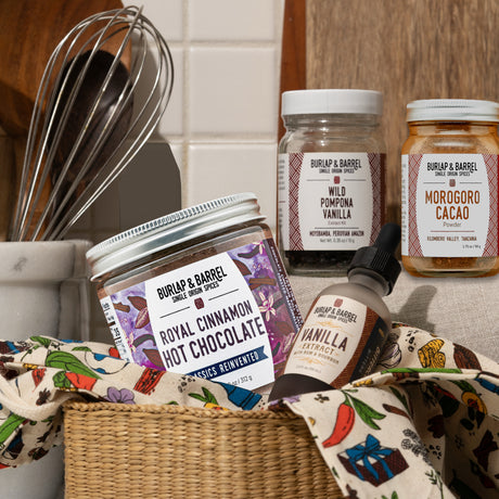 Burlap & Barrel food products including hot chocolate, vanilla extract, and cocoa powder on a kitchen counter.