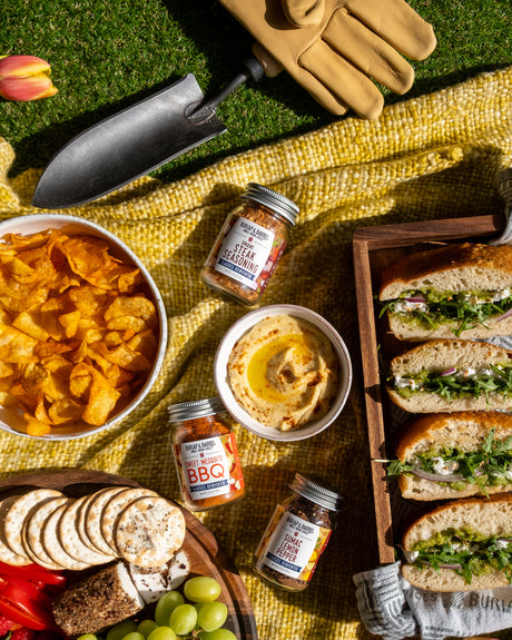 Outdoor picnic setup with food items on a yellow blanket