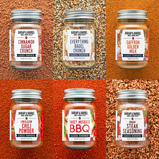 Jars of Burlap & Barrel seasoning mixes on a textured orange background