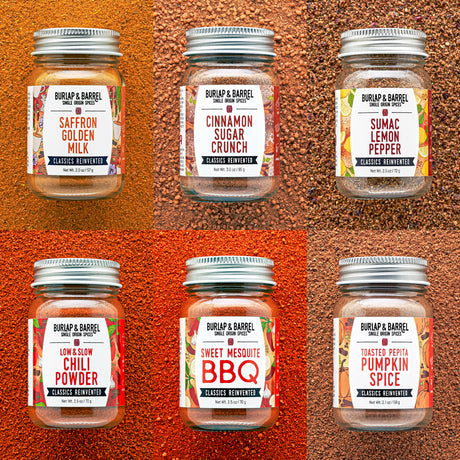 Six jars of Burlap & Barrel spices on a textured brown background