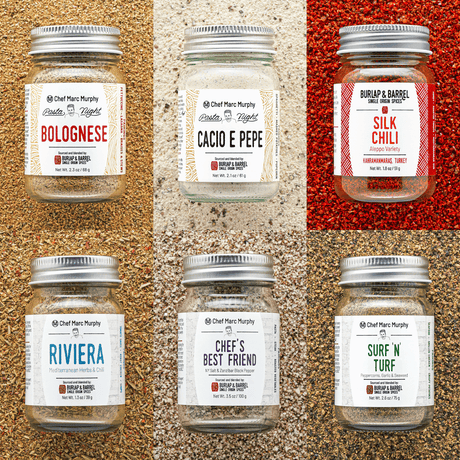 Six jars of Burlap & Barrel pasta night sauces with labels on a textured surface.