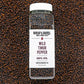 A bottle of Wild Timur Pepper by Burlap & Barrel, with the label showing the product name and origin, amidst loose peppers.