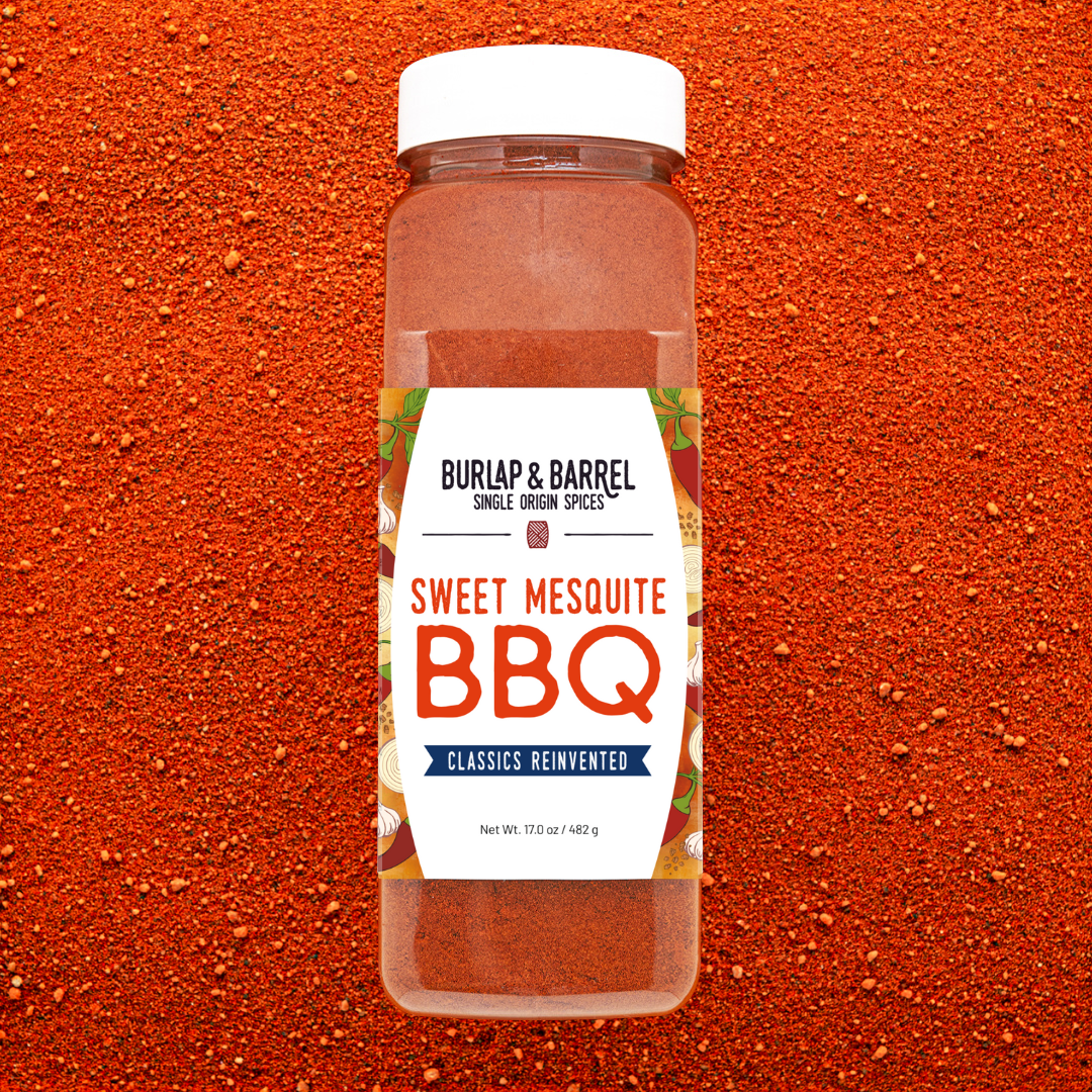 Container of Burlap & Barrel Sweet Mesquite BBQ spice seasoning on an orange background